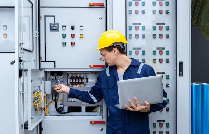 man with a laptop in hand configuring energy management system