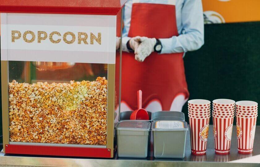 image showing popcorn machine with a man making popcorn